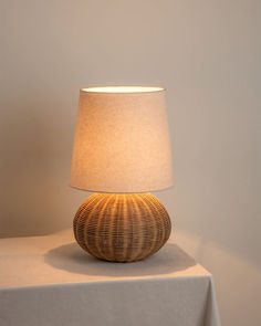 a lamp sitting on top of a table next to a white cloth covered tablecloth