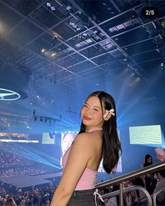 a woman standing in front of a crowd at a concert