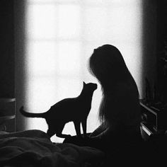 a black and white photo of a woman with her cat