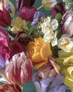 a bunch of flowers that are sitting in a vase on a table with green background