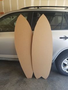 two surfboards are propped up against the back of a car