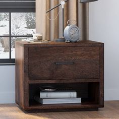 a night stand with books and an alarm clock on it in front of a window