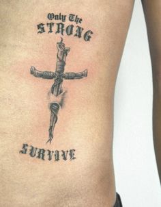 a cross tattoo with the words only the strong survive