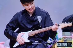 a young man playing an electric guitar on stage