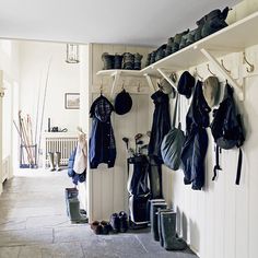 an entry way with several coats and shoes hanging on the wall, along with other items