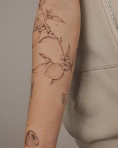 a woman's arm with a flower tattoo on the left side of her arm