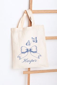 Experience elegance in every detail with our Personalized Blue Coquette Bow and Butterflies Canvas Tote Bag, perfect for everyday use – whether you're running errands or heading to brunch. Looking for a unique gift? Surprise a loved one with this personalized tote, ideal for birthdays, anniversaries, or bridesmaid gifts. #canvastotebag #personalizedgift #teengirlgift