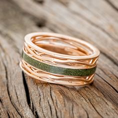 three bands of gold and green leather are stacked on top of each other in the shape of rings