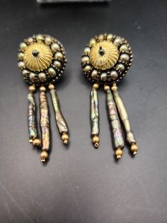 Gold metal bead in the shape of a sea urchin has stick pearls dangling from it reminiscent of the ocean. Gold metal stud posts are attached for wearing. Augusta Ga, Metal Bead, Sea Urchin, A Sea, Metal Beads, The Ocean, Jewelry Earrings Dangle, Gold Metal, Dangle Drop Earrings