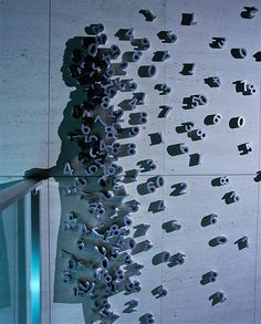 a person standing in front of a wall with many rolls of toilet paper on it