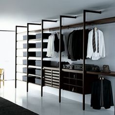 an open closet with clothes hanging on shelves