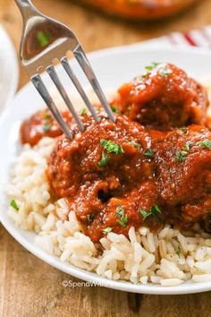 meatballs and rice on a plate with a fork