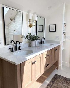 a bathroom with two sinks and mirrors on the wall