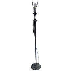 a black floor lamp with a white light on it