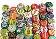 a pile of beer bottle caps sitting next to each other on top of a white surface