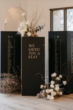 three black and white seating signs with flowers on them