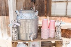 pink and silver vases sitting on top of a wooden shelf next to other items