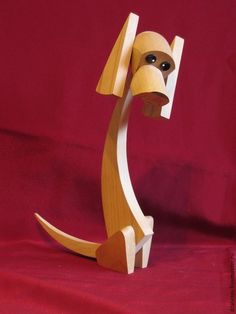 a wooden sculpture of a dog on a red background