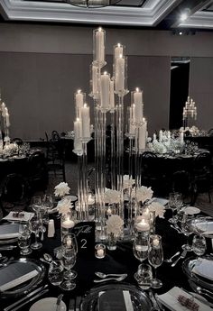 an elegant table setting with candles and flowers on the centerpieces is shown in black and white