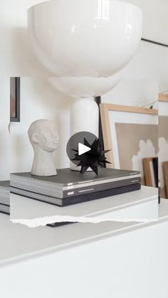 a white table topped with books and sculptures