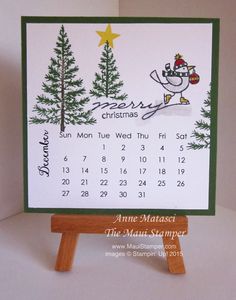 a calendar with a bird on it sitting on top of a wooden easel in front of a white background