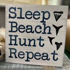 a sign that says sleep beach hunt repeat on it's wooden board with the words