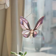 a stained glass butterfly hanging from a window