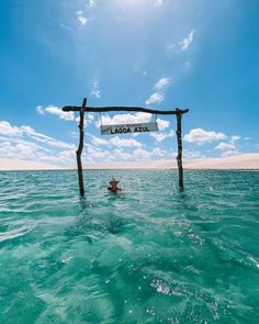 a person floating in the ocean under a sign