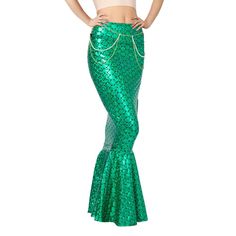 a woman in a green mermaid costume with her hands on her hips, posing for the camera