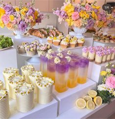 there are many cupcakes on the table with flowers and lemons in them