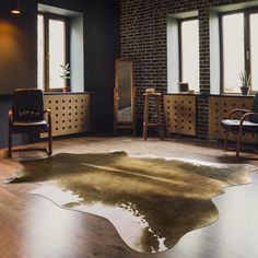 a living room filled with furniture and windows next to a wooden floor covered in cowhide