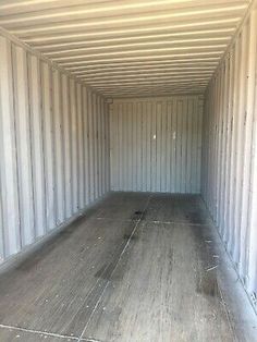 the inside of a storage container with wood flooring and white walls is shown in this image