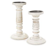 two white wooden candlesticks sitting next to each other