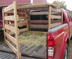 the back end of a red truck with hay in it