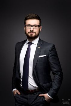 a man in a suit and tie is posing for a photo with his hands on his hips