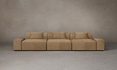 a beige couch sitting on top of a gray floor