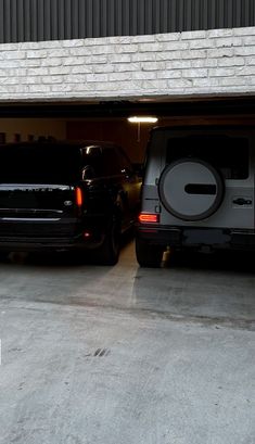 two vehicles are parked in a garage with their doors open and there is no one inside