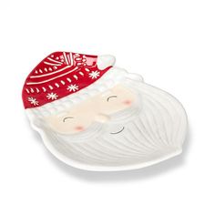 a white plate with a red santa clause on it's face and snowflakes on its head