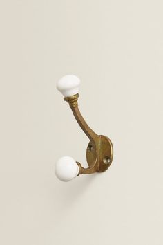 an old fashioned brass door handle with two white knobs