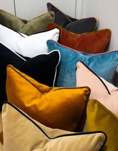 a bunch of pillows sitting on top of each other in front of a white door