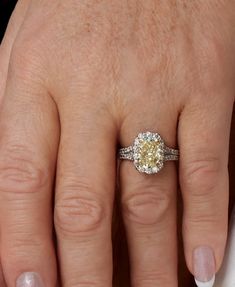 a close up of a person's hand with a diamond ring on their finger