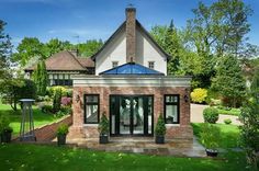 a brick house with glass doors in the front yard