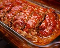 meatloaf in a glass casserole dish with sauce on top and slices cut out