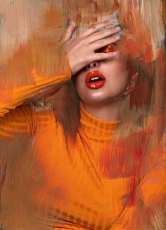 a woman with her hands on her face and red lipstick in front of an abstract painting