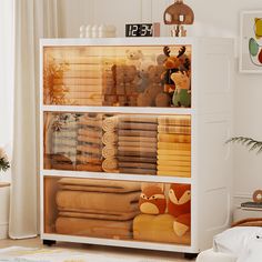 a white cabinet filled with lots of towels and stuffed animals on it's sides