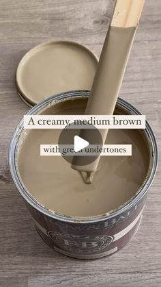 a creamy medium brown paint with grey undertones is being poured onto a wooden table