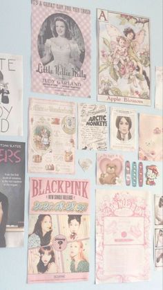 there are many posters on the wall in this room that is decorated with pink and white