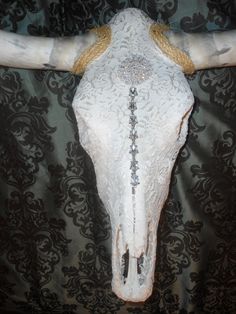 the cow skull is adorned with gold and crystal beads