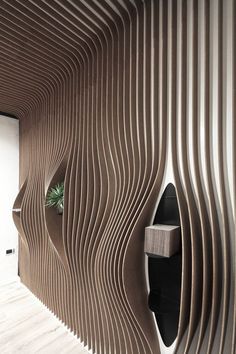 an artisticly designed room with wood slats on the wall and wooden flooring