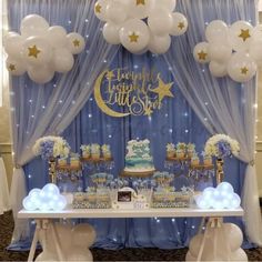 a blue and white dessert table with balloons